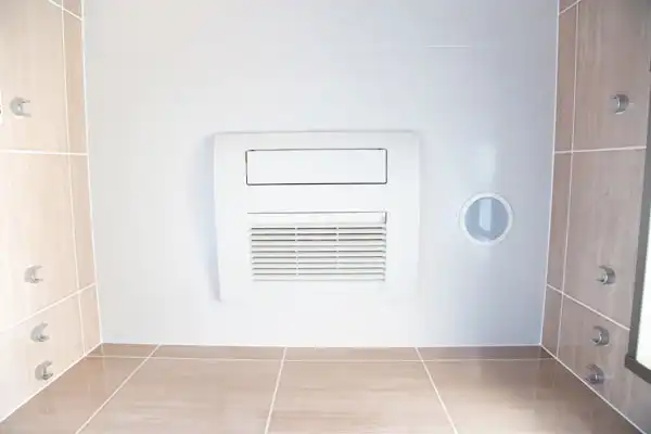 View of a ceiling-mounted air conditioner in a tiled room corner, featuring eight metallic fixtures distributed on the walls.